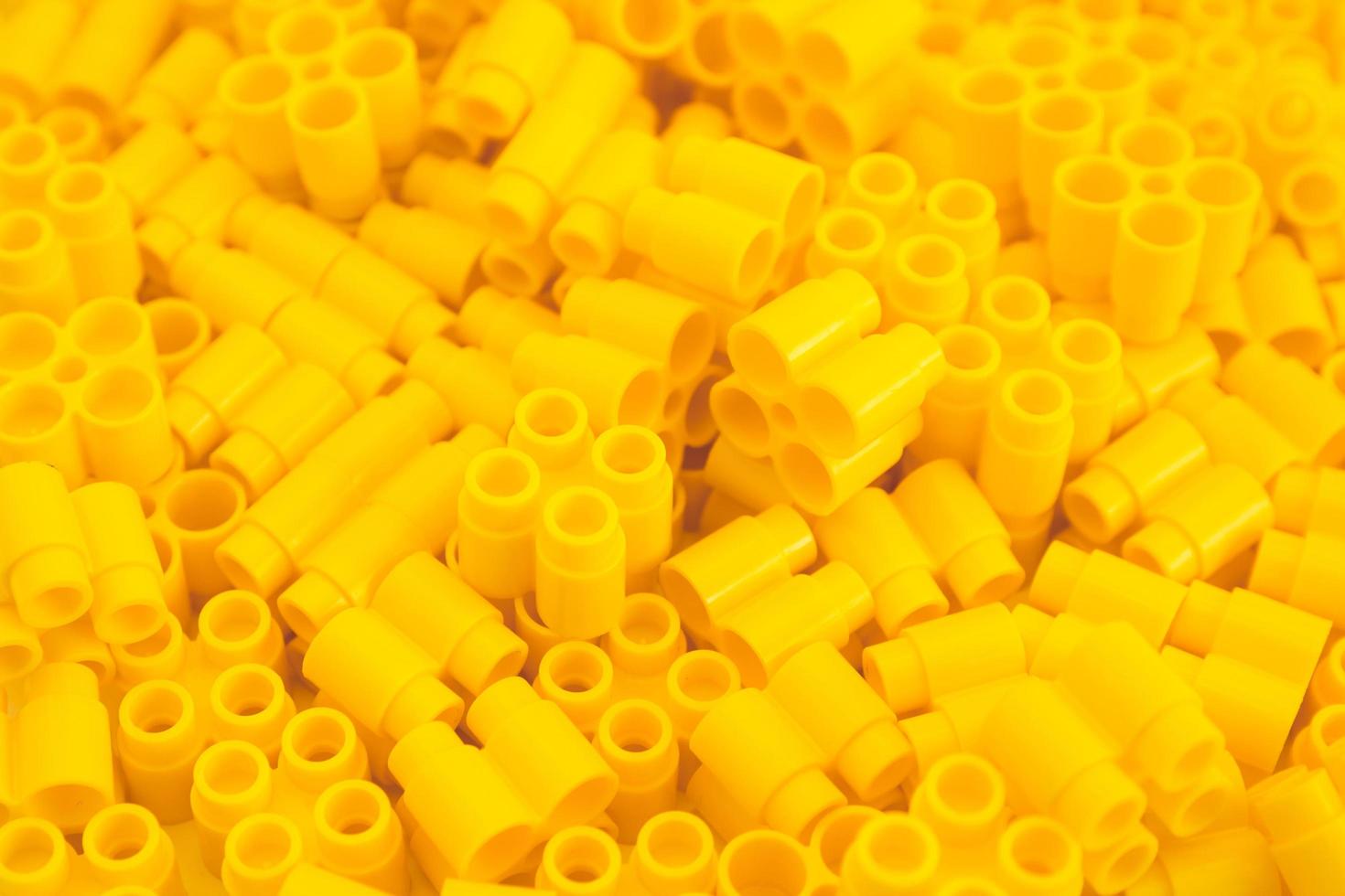 Plastic bricks of yellow color as a background texture photo