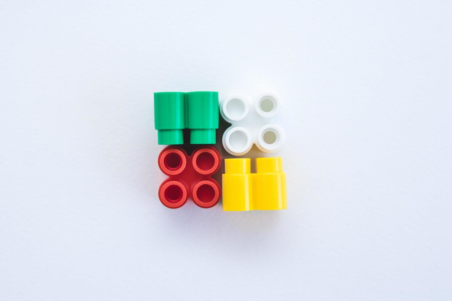 Colorful plastic bricks and details of toys on a white background photo