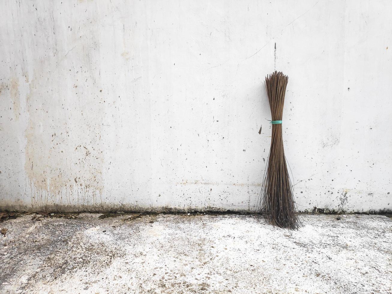 Broom stick on white wall background photo