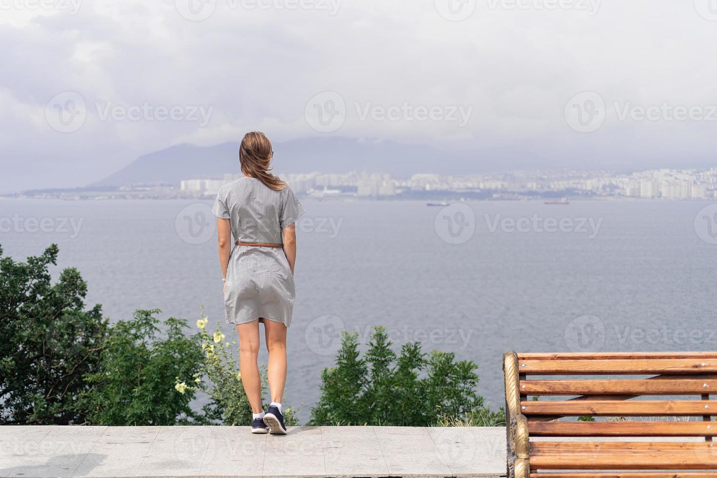 vista trasera, de, mujer joven, mirar el paisaje urbano foto