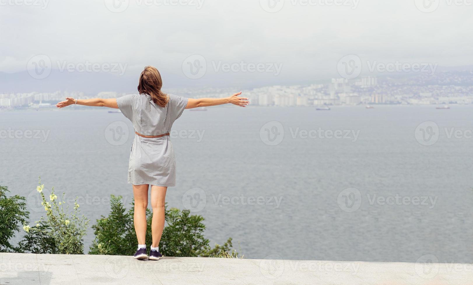 vista trasera, de, mujer joven, mirar el paisaje urbano foto