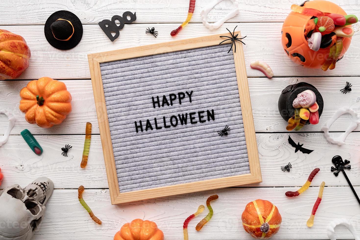 Happy Halloween words on gray letter board with candy flat lay photo