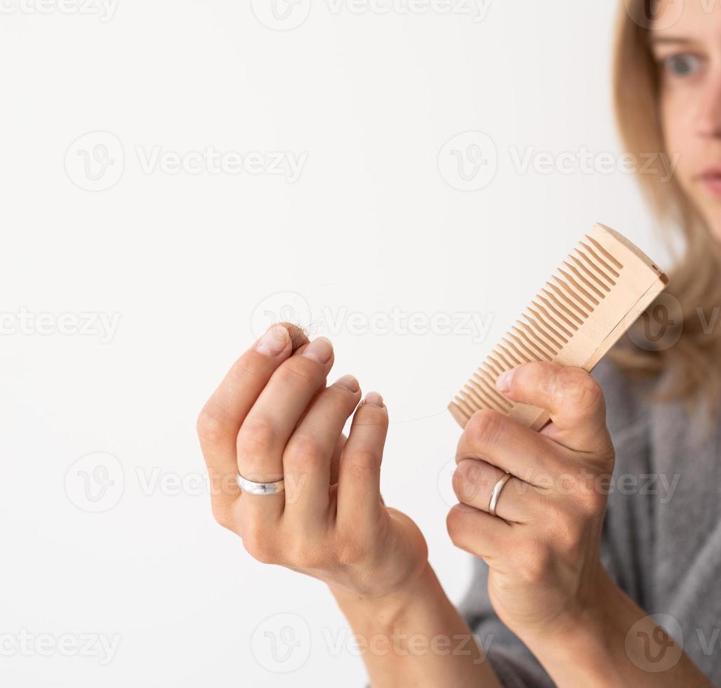 Woman brushing her hair suffering from hairloss photo