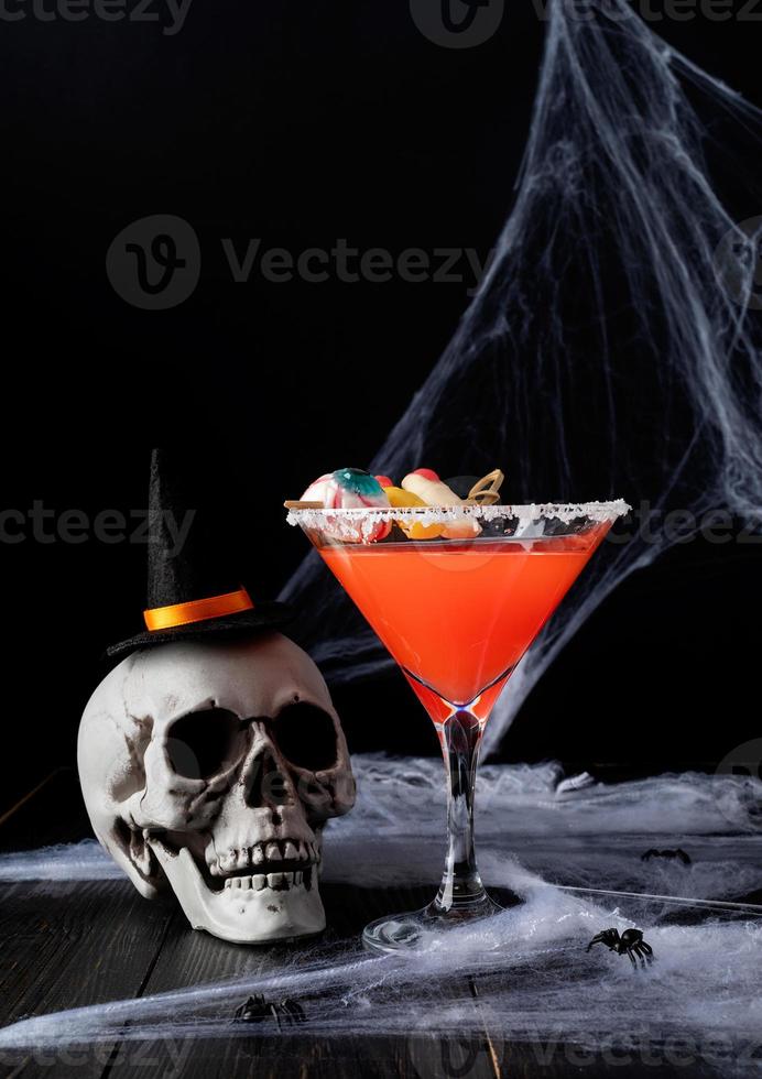 Scary colorful Halloween cocktail with party decorations on dark photo