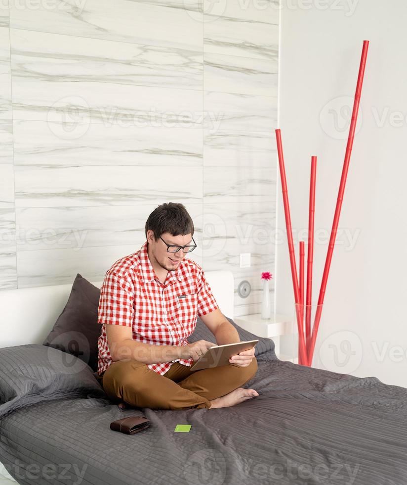 Young man shopping on internet with tablet photo