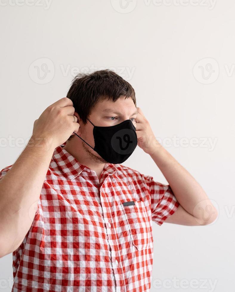 Young man putting on a protective mask photo