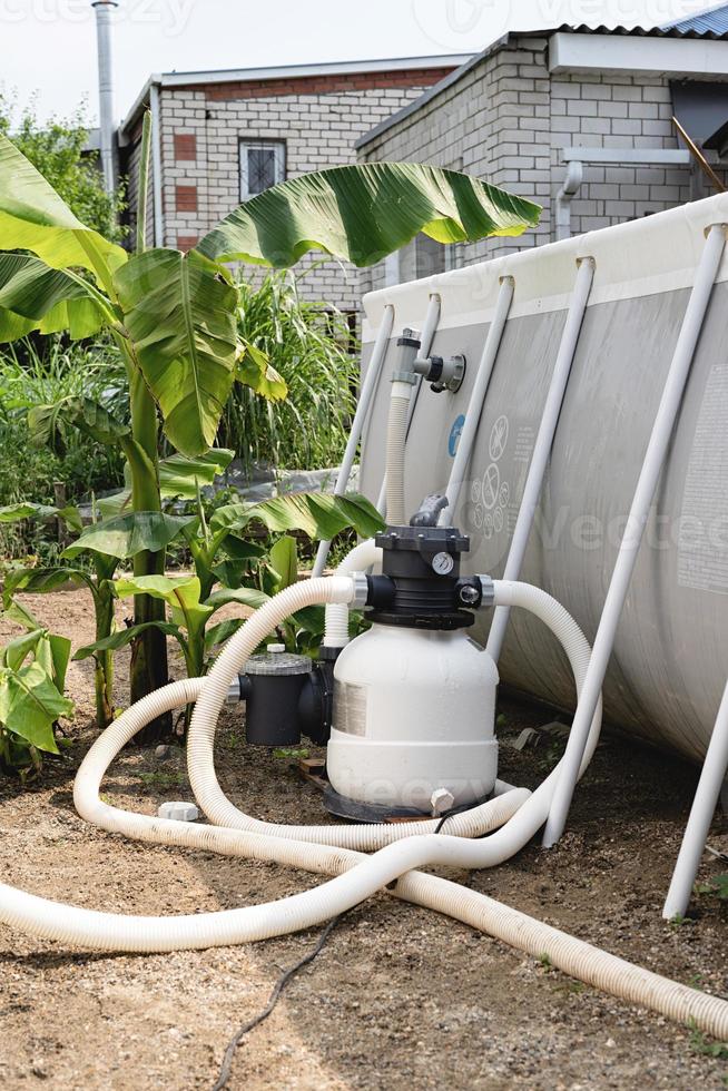 Sand filter plant at a pool in the garden photo