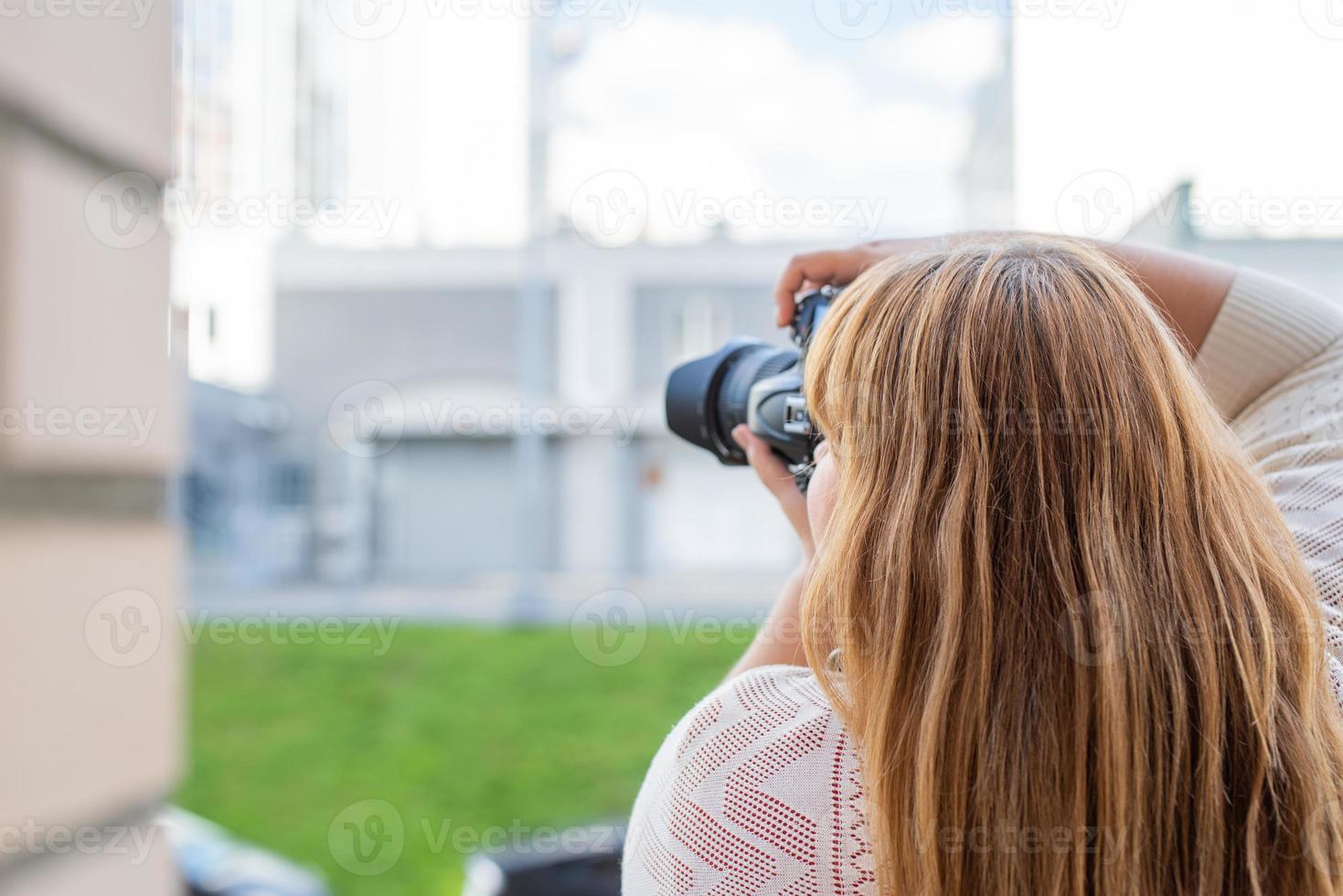 Portrait of overweight woman taking pictures with a camera outdoors photo