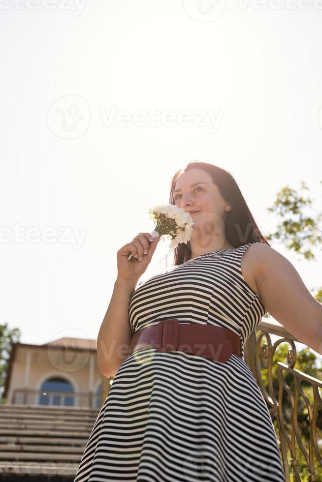 Portrait of laughing woman holding a bouquet of flowers photo