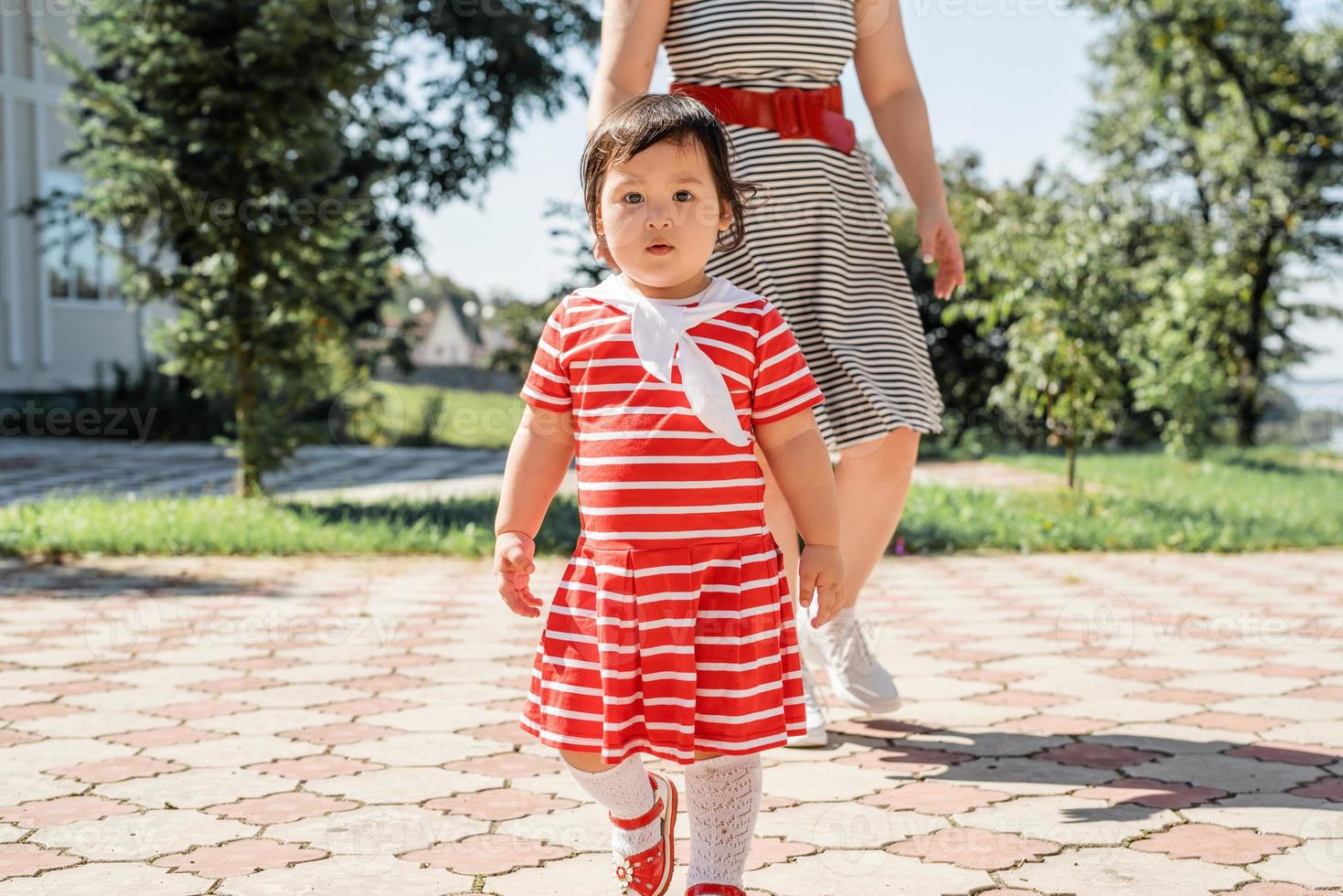 Feliz familia multirracial de madre e hija caminando en el parque foto