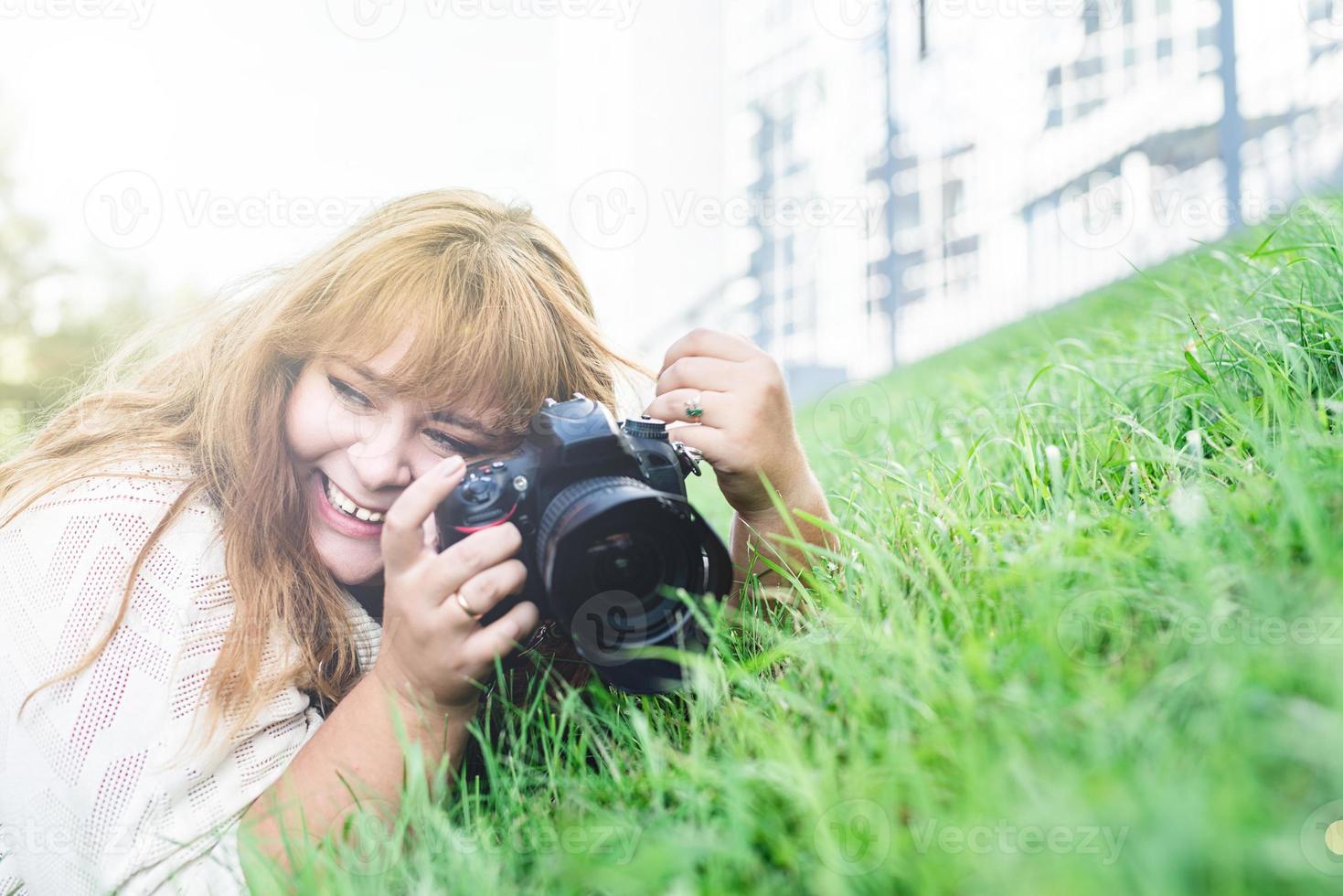 Portrait of overweight woman taking pictures with a camera in the park photo