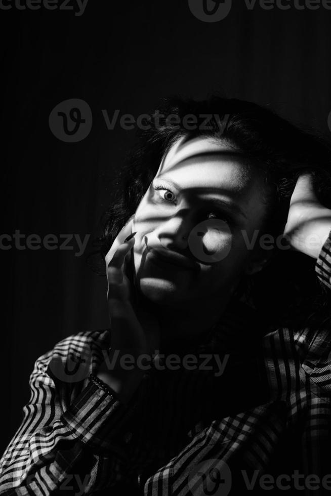 retrato de una bella mujer joven con un patrón de sombra en la cara foto