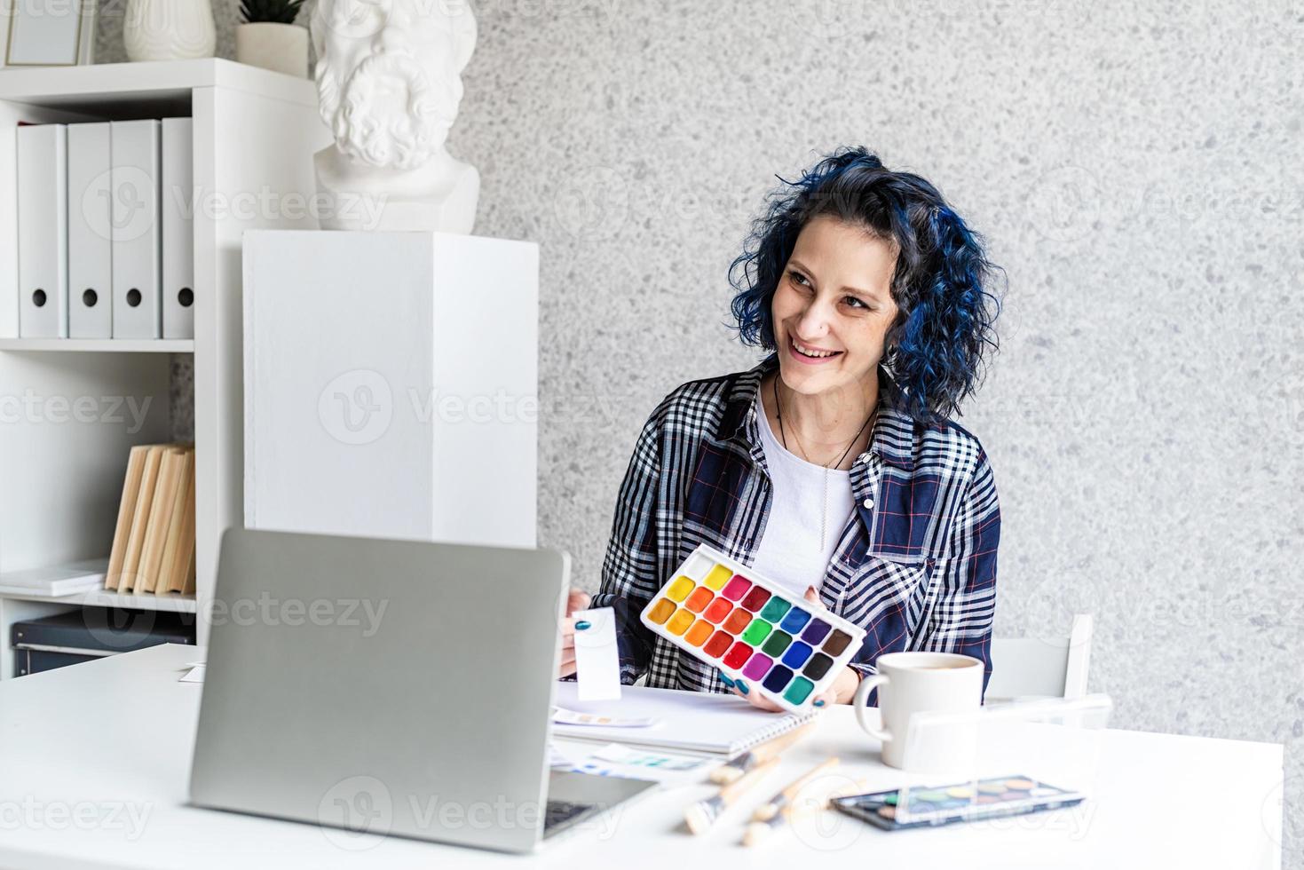 Diseñador que trabaja con paletas de colores y un portátil en su estudio. foto