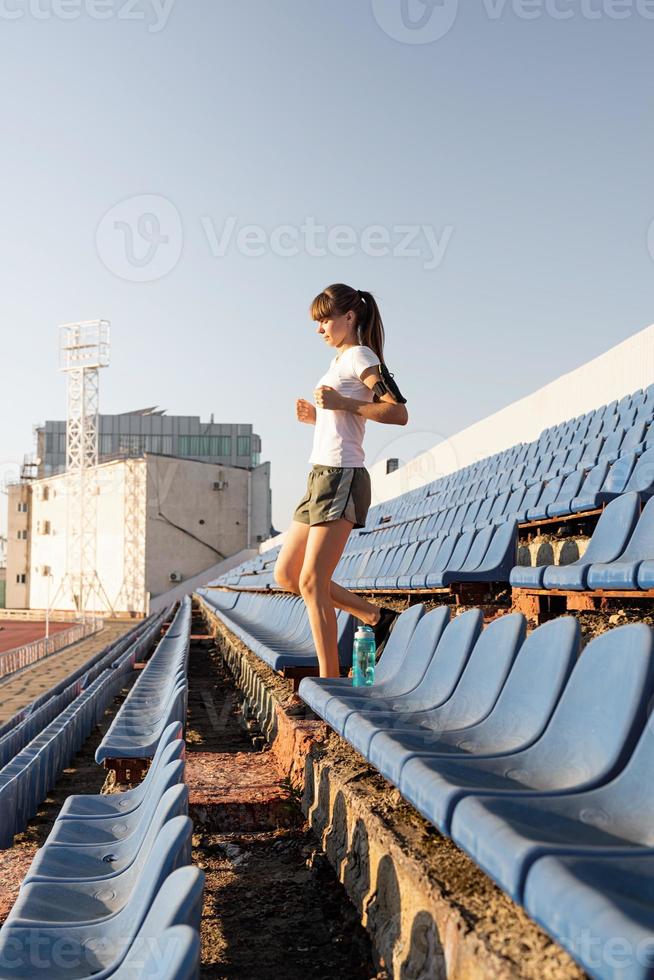 Chica adolescente trabajando en el staduim bajando las escaleras foto