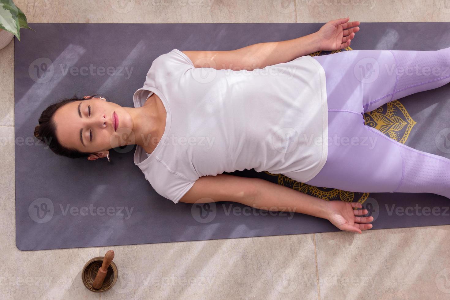 Beautiful woman in relaxation posture with a Tibetan singing bowl photo