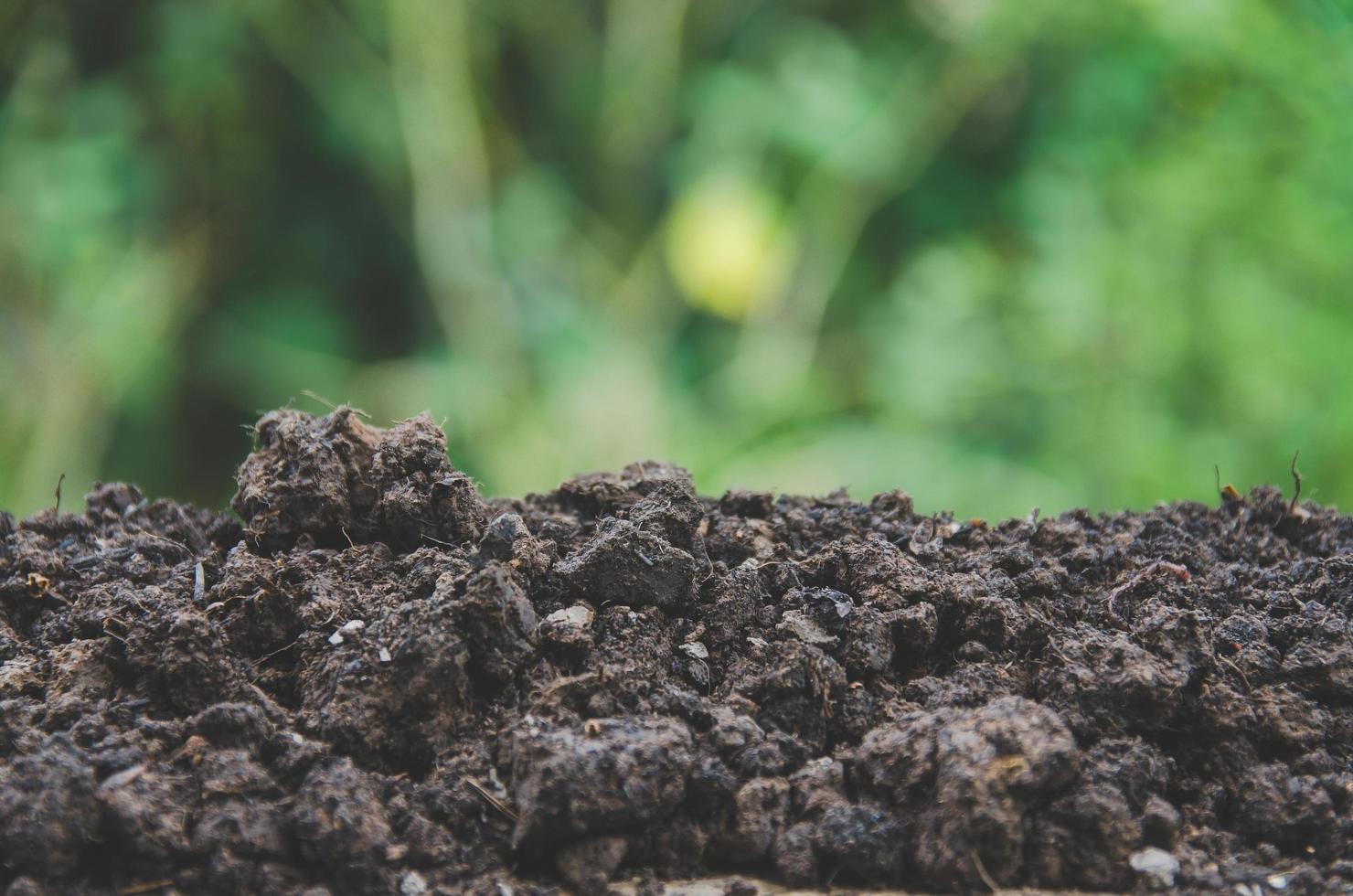 preparación de suelo para la agricultura y montón de suelo con fondo verde. foto