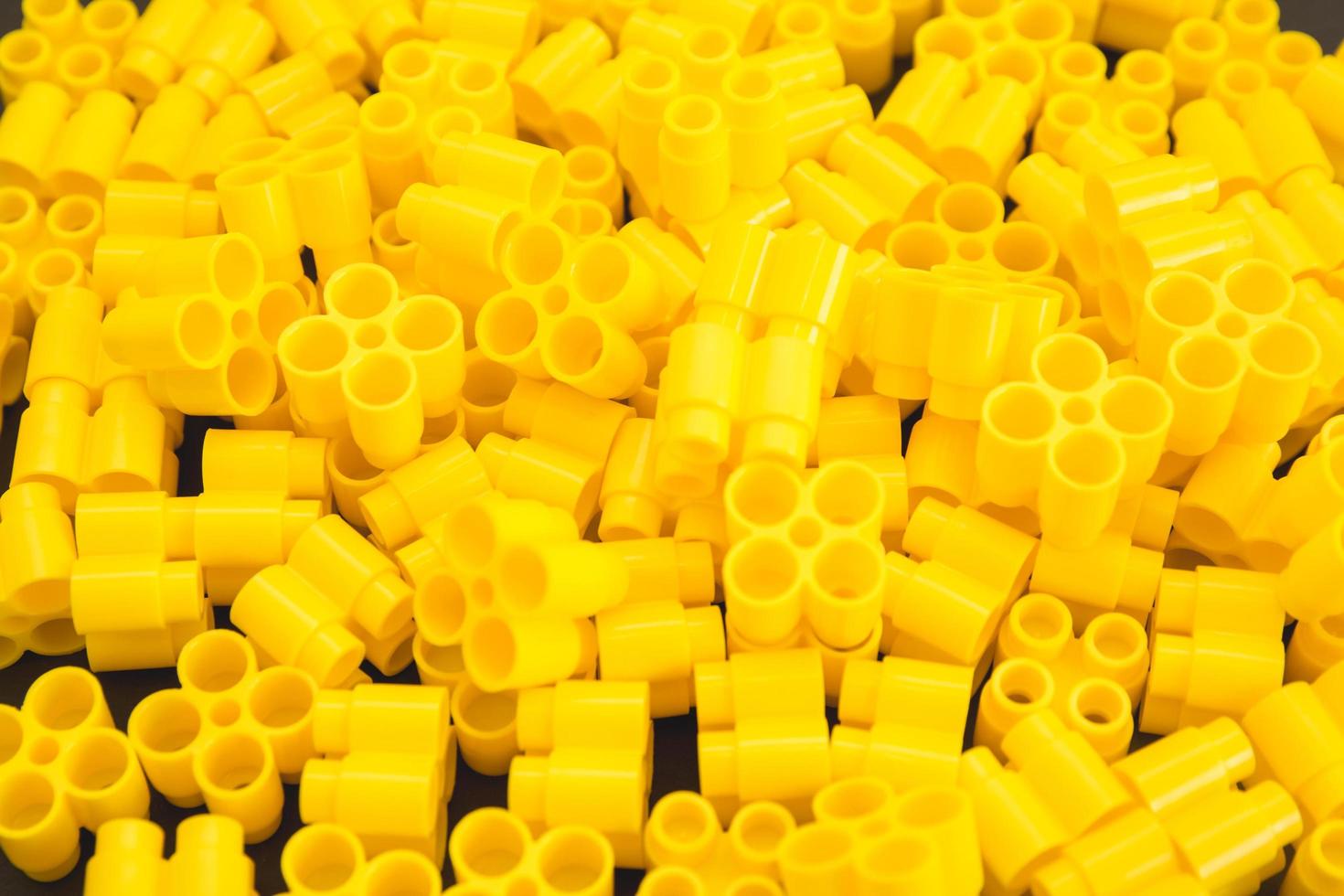 Plastic bricks of yellow color as a background texture photo