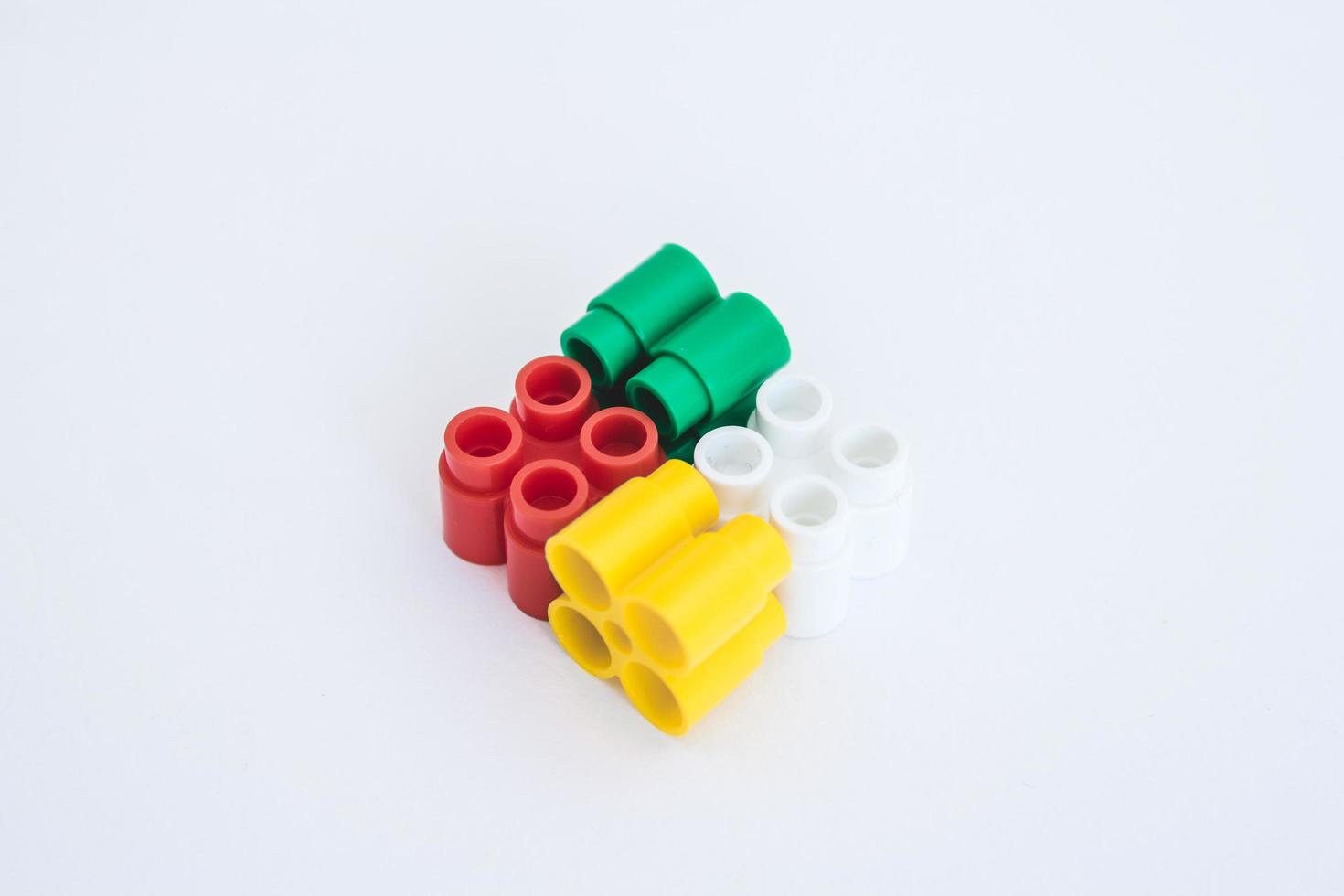 Colorful plastic bricks and details of toys on a white background photo