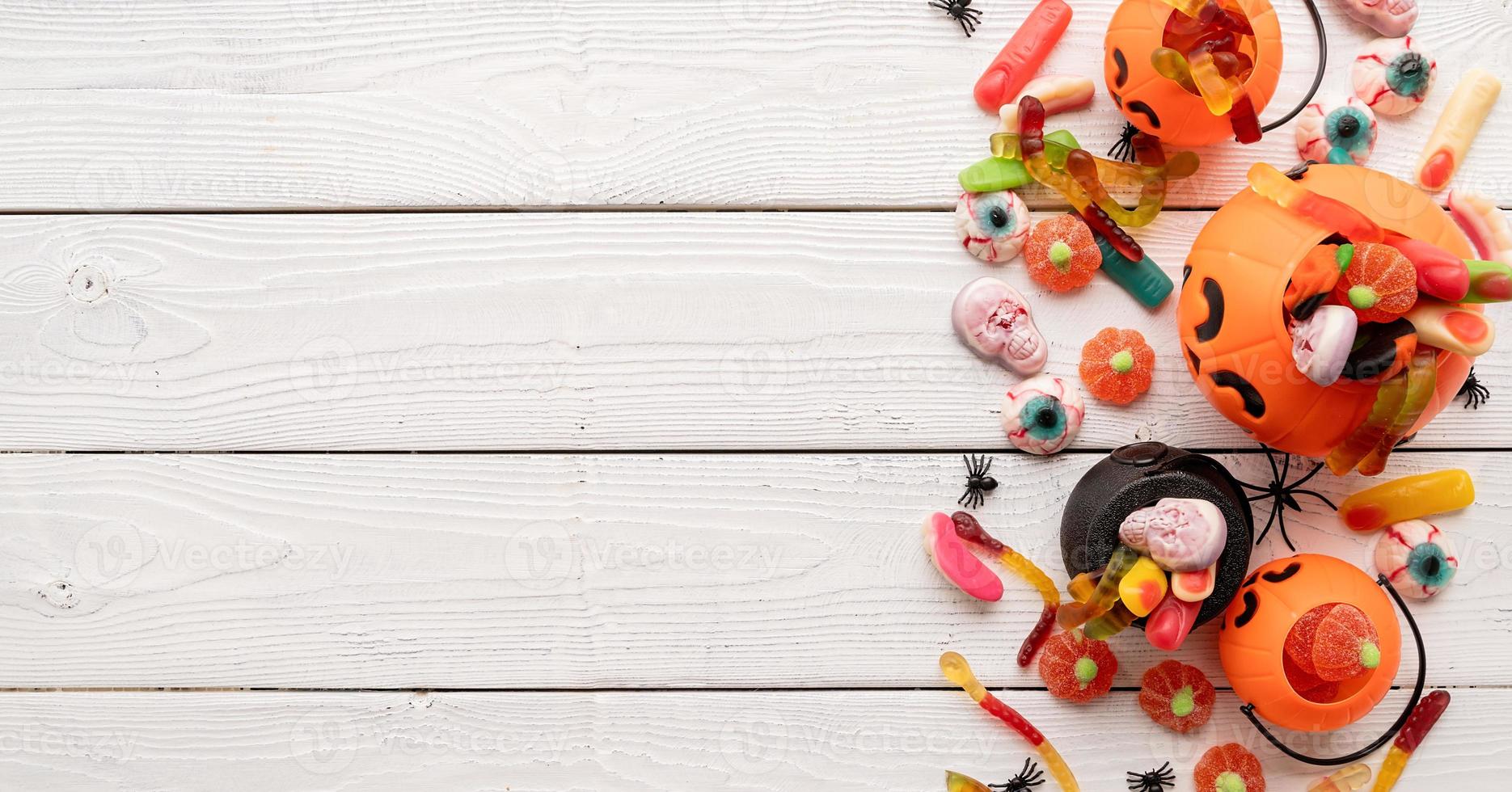 Dulces de colores para la fiesta de Halloween sobre fondo blanco de madera foto