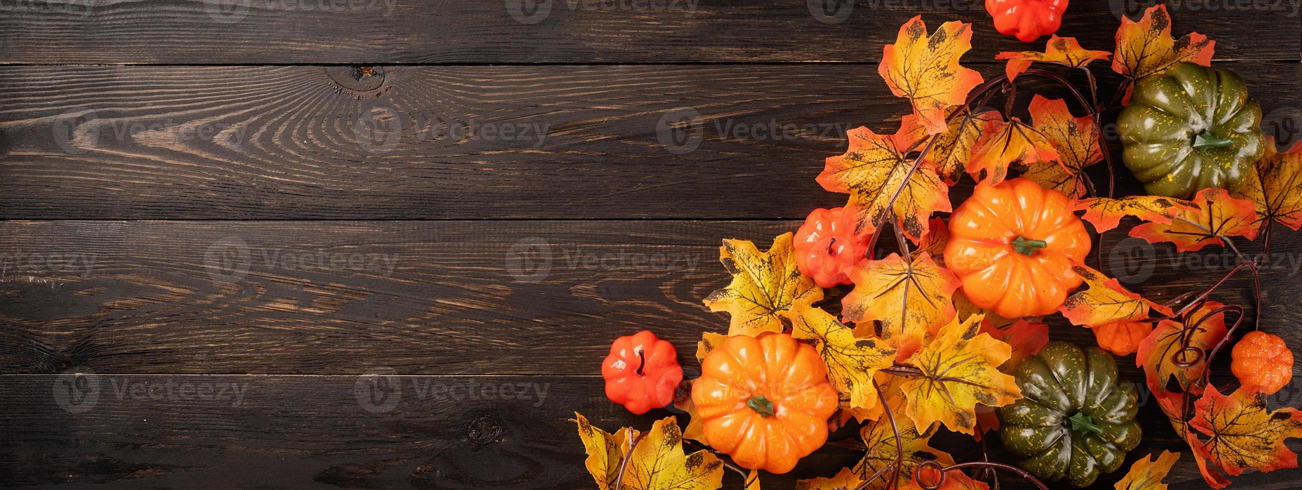 Decorations with pumpkins and leaves, top view on black background photo