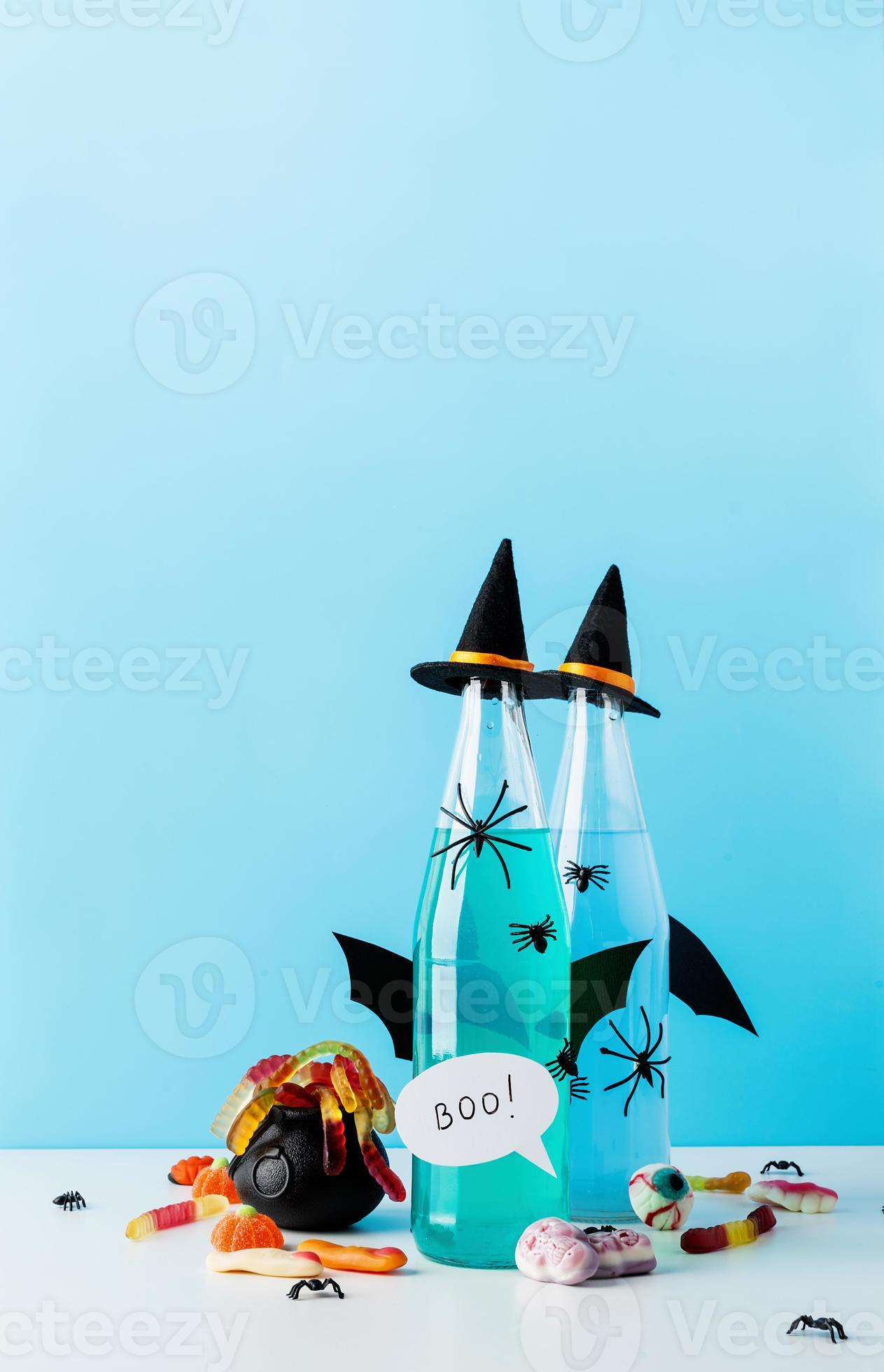 Colorful Halloween cocktails with party decorations on blue background