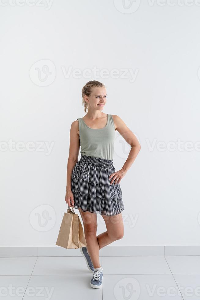 Mujer sonriente sosteniendo bolsas de compras ecológicas foto