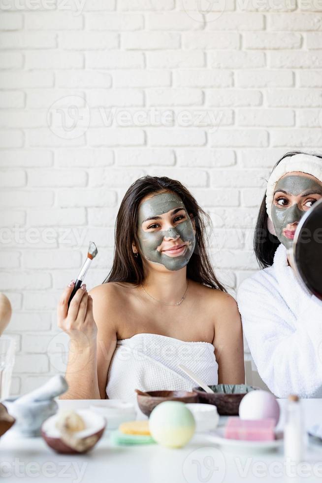 Bella mujer aplicando mascarilla facial haciendo procedimientos de spa foto