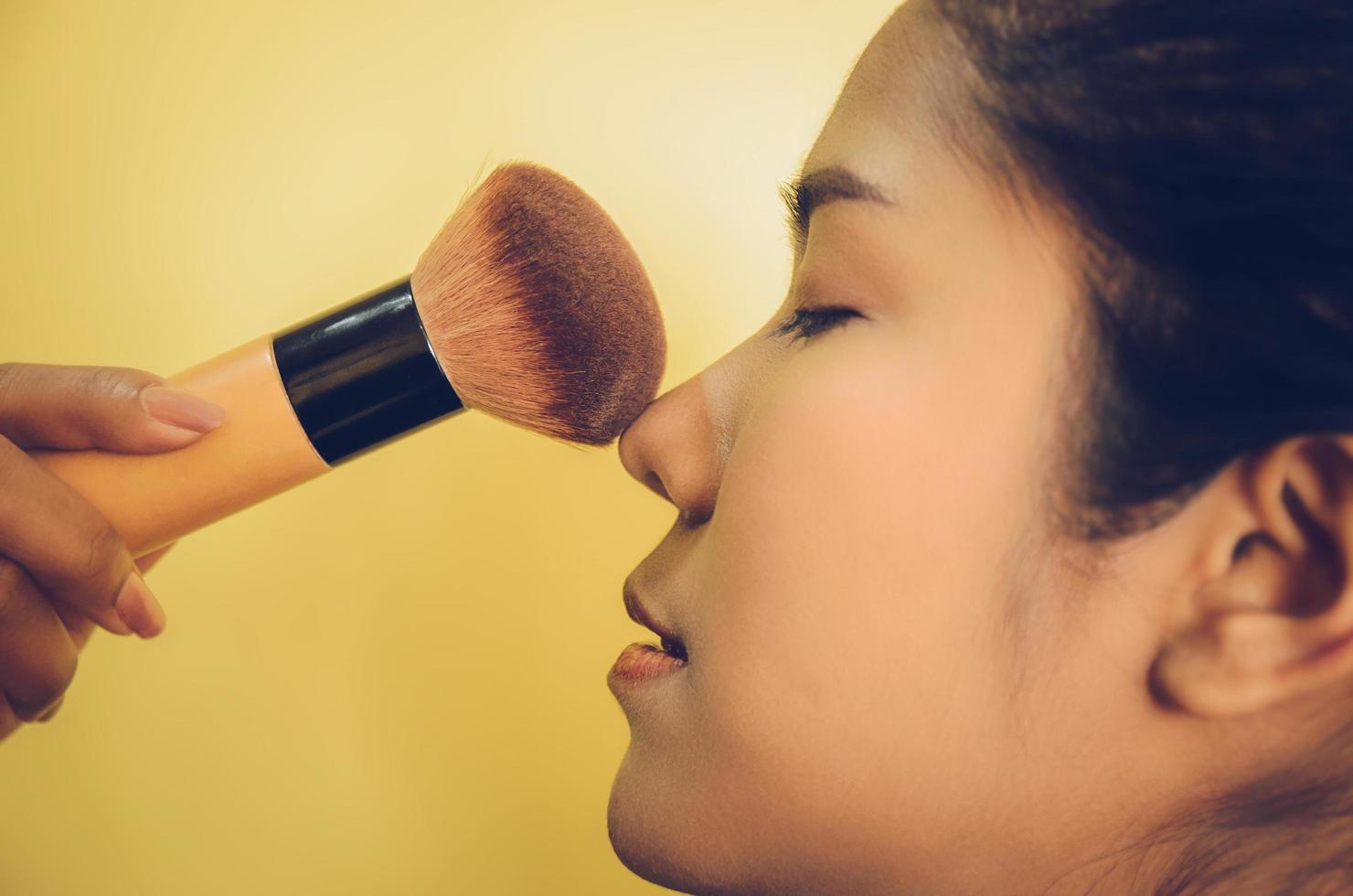 Beauty face of Asian woman by applying brushes on skin by cosmetics. photo