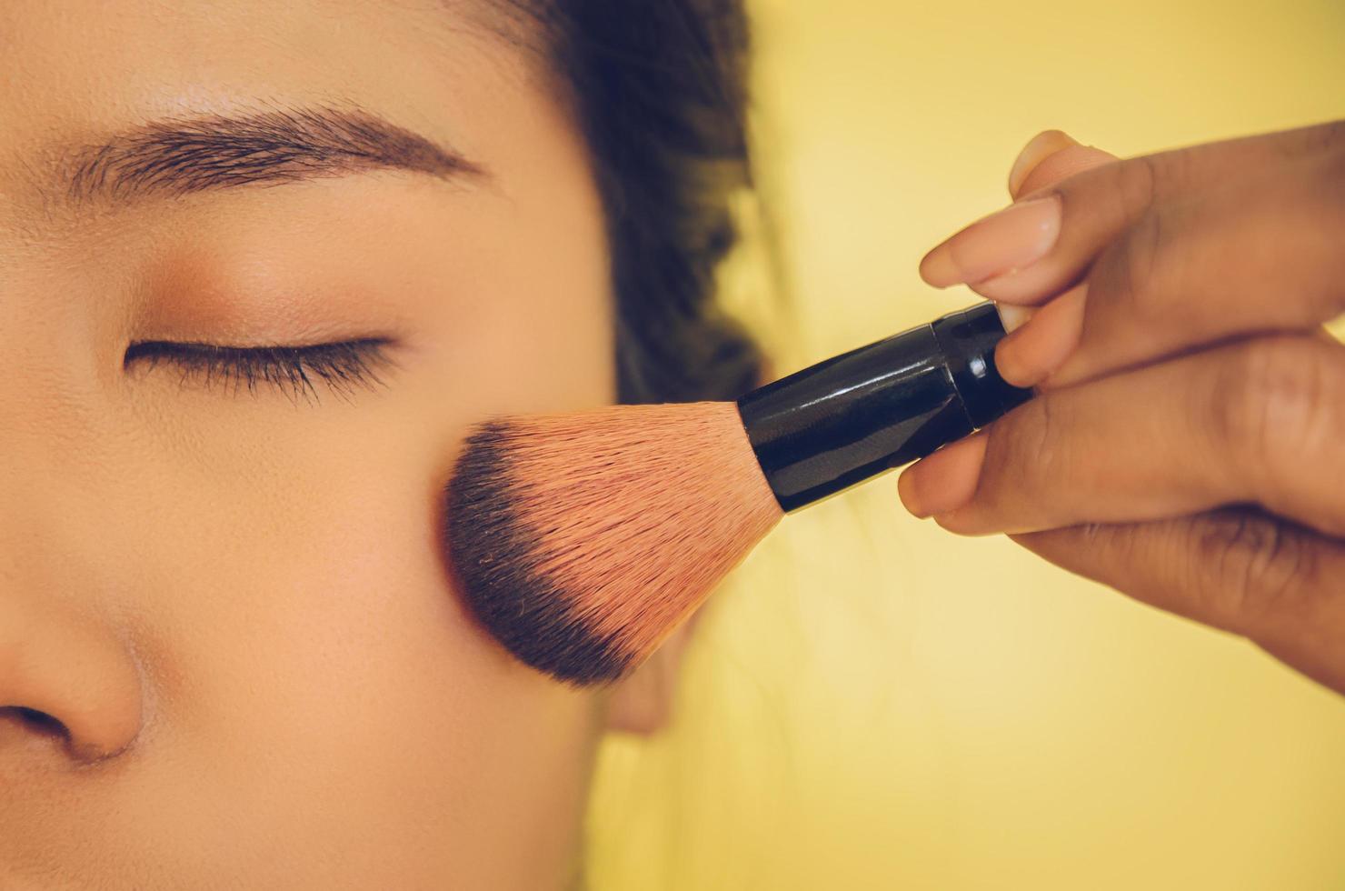 Beauty face of Asian woman by applying brushes on skin by cosmetics. photo