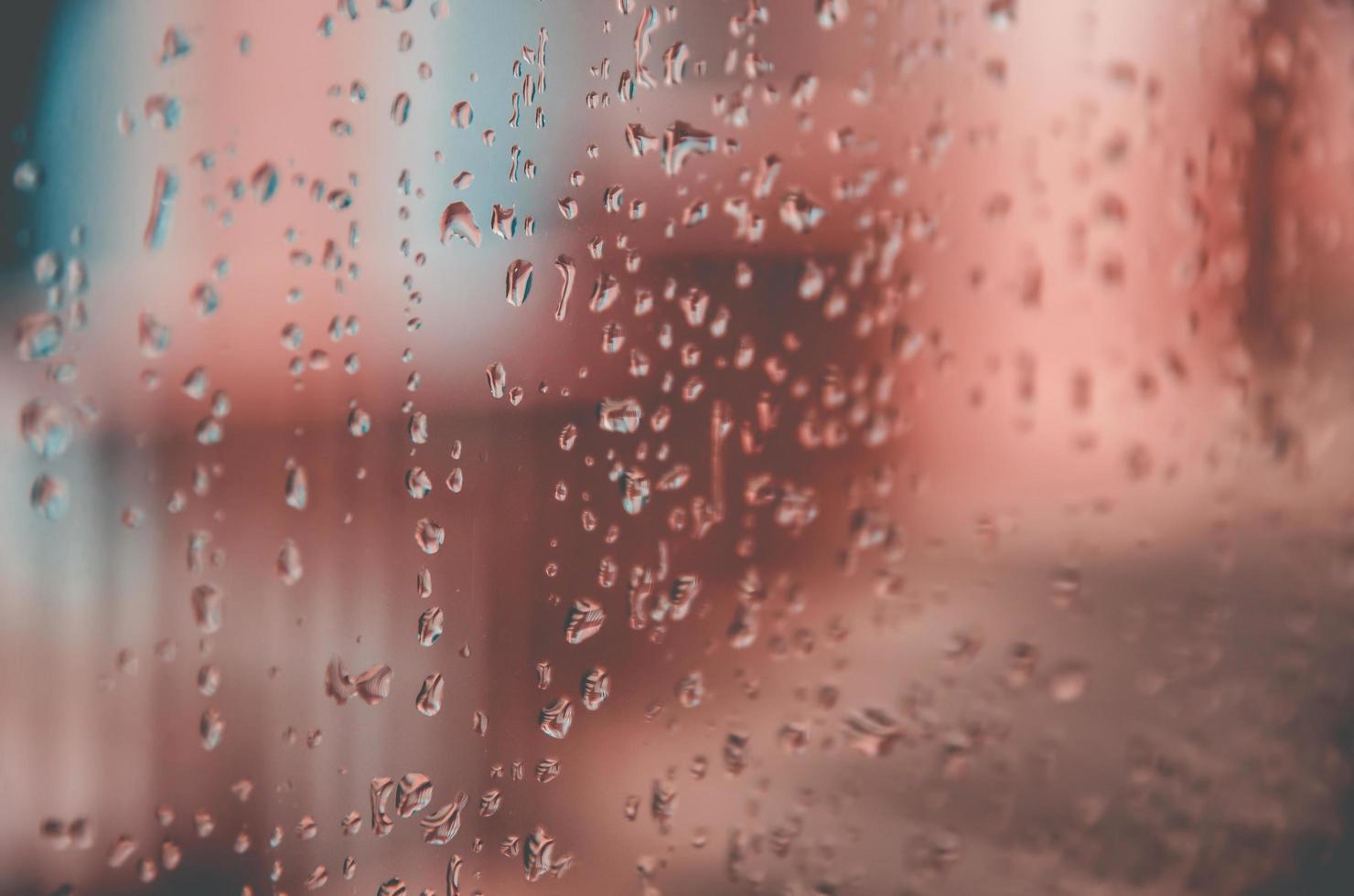 Fondo y papel tapiz por gota de lluvia y gotas de agua en la ventana. foto