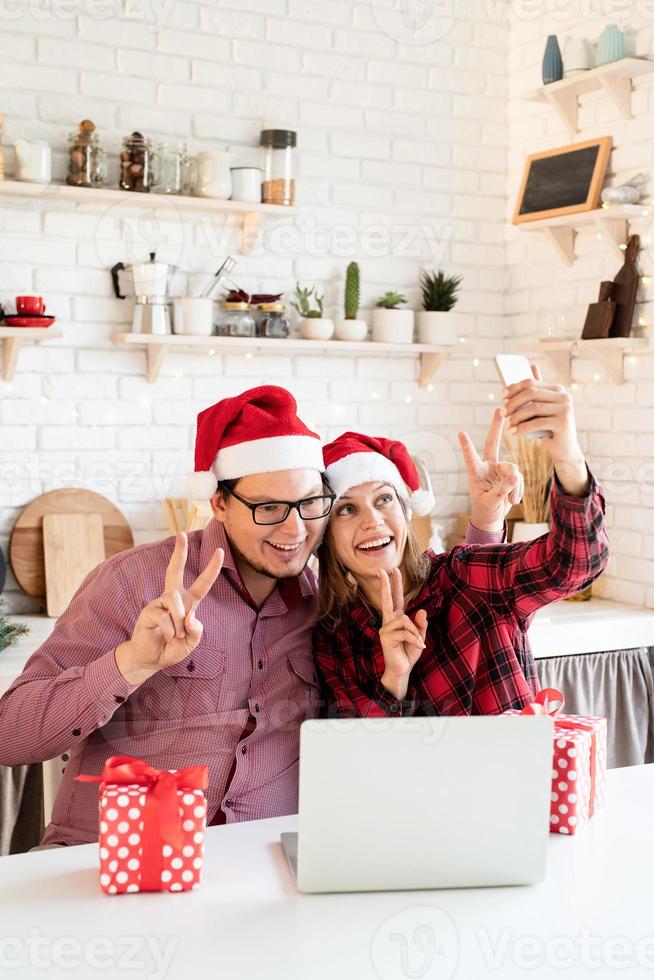 pareja saludando a sus amigos en una videollamada en la computadora portátil foto