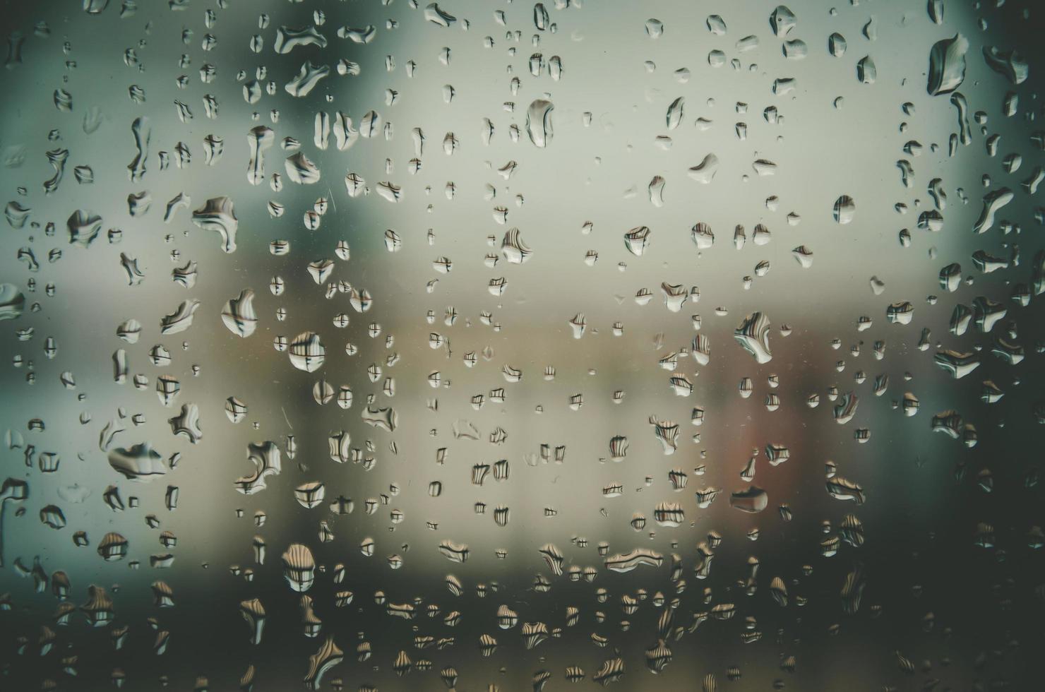 Fondo y papel tapiz por gota de lluvia y gotas de agua en la ventana. foto