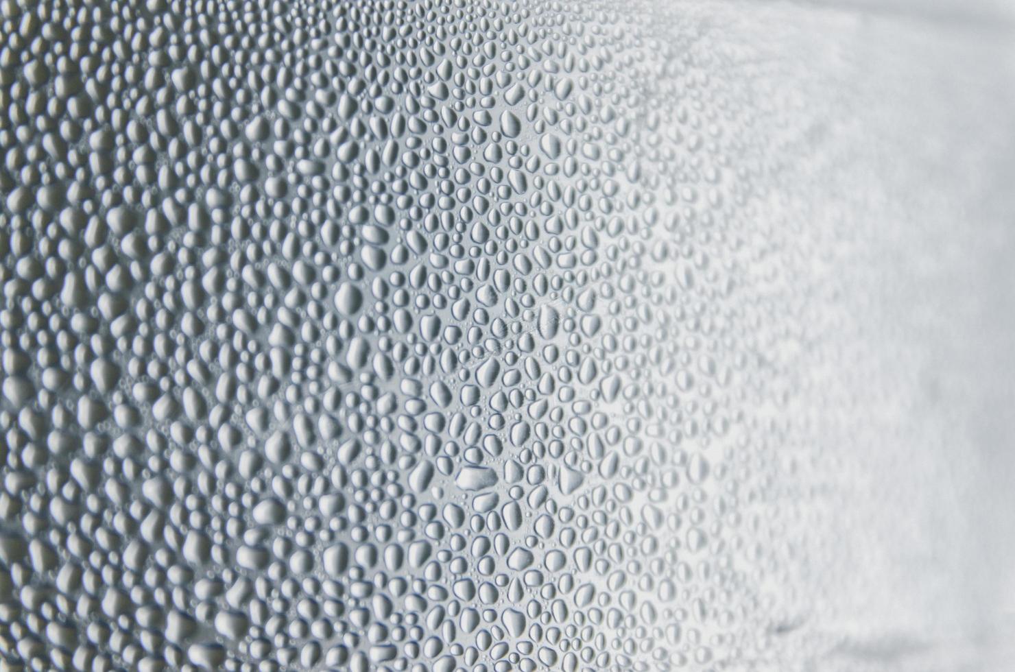 Fondo y papel tapiz por gota de lluvia y gotas de agua en la ventana. foto