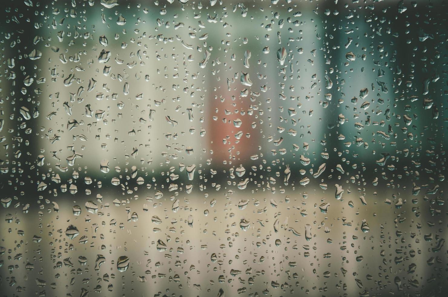 Fondo y papel tapiz por gota de lluvia y gotas de agua en la ventana. foto