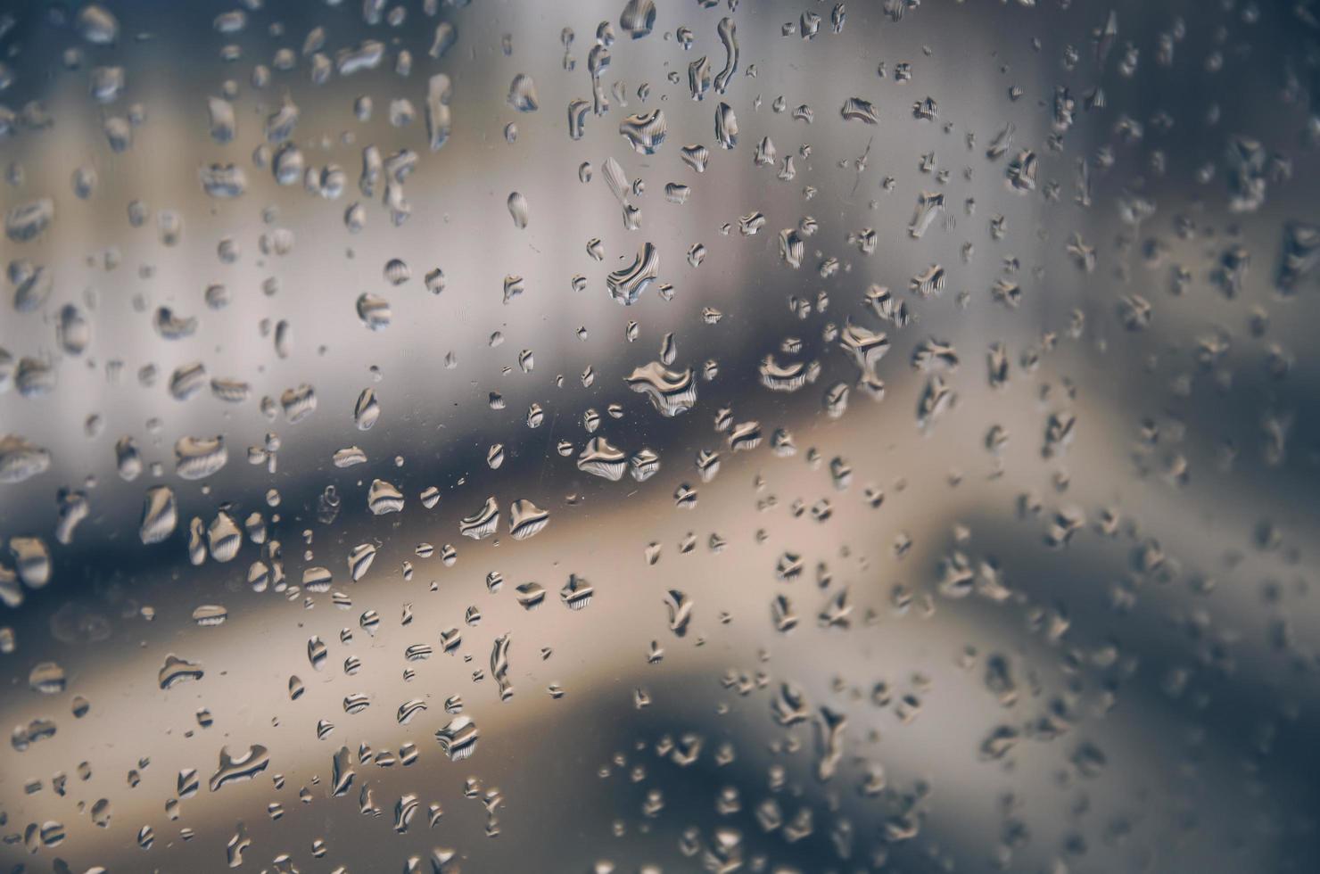 Fondo y papel tapiz por gota de lluvia y gotas de agua en la ventana. foto