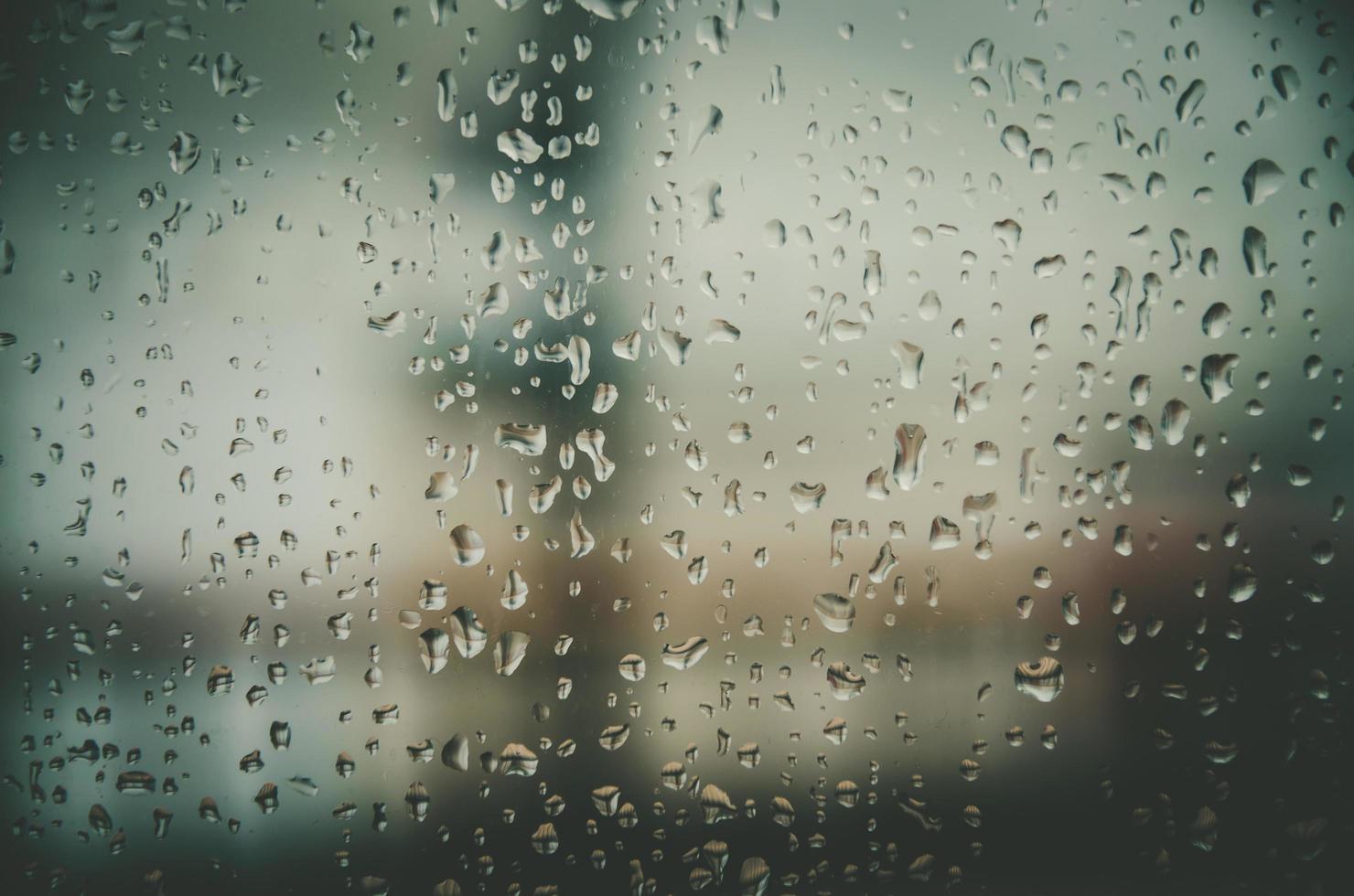 Fondo y papel tapiz por gota de lluvia y gotas de agua en la ventana. foto