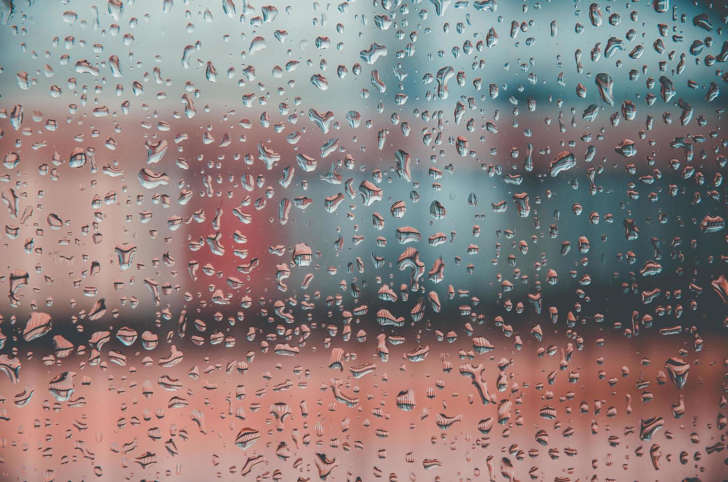 Fondo y papel tapiz por gota de lluvia y gotas de agua en la ventana. foto