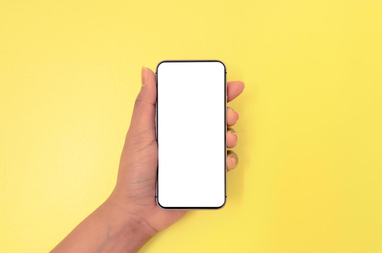 A hand holding smartphone with white screen background. photo
