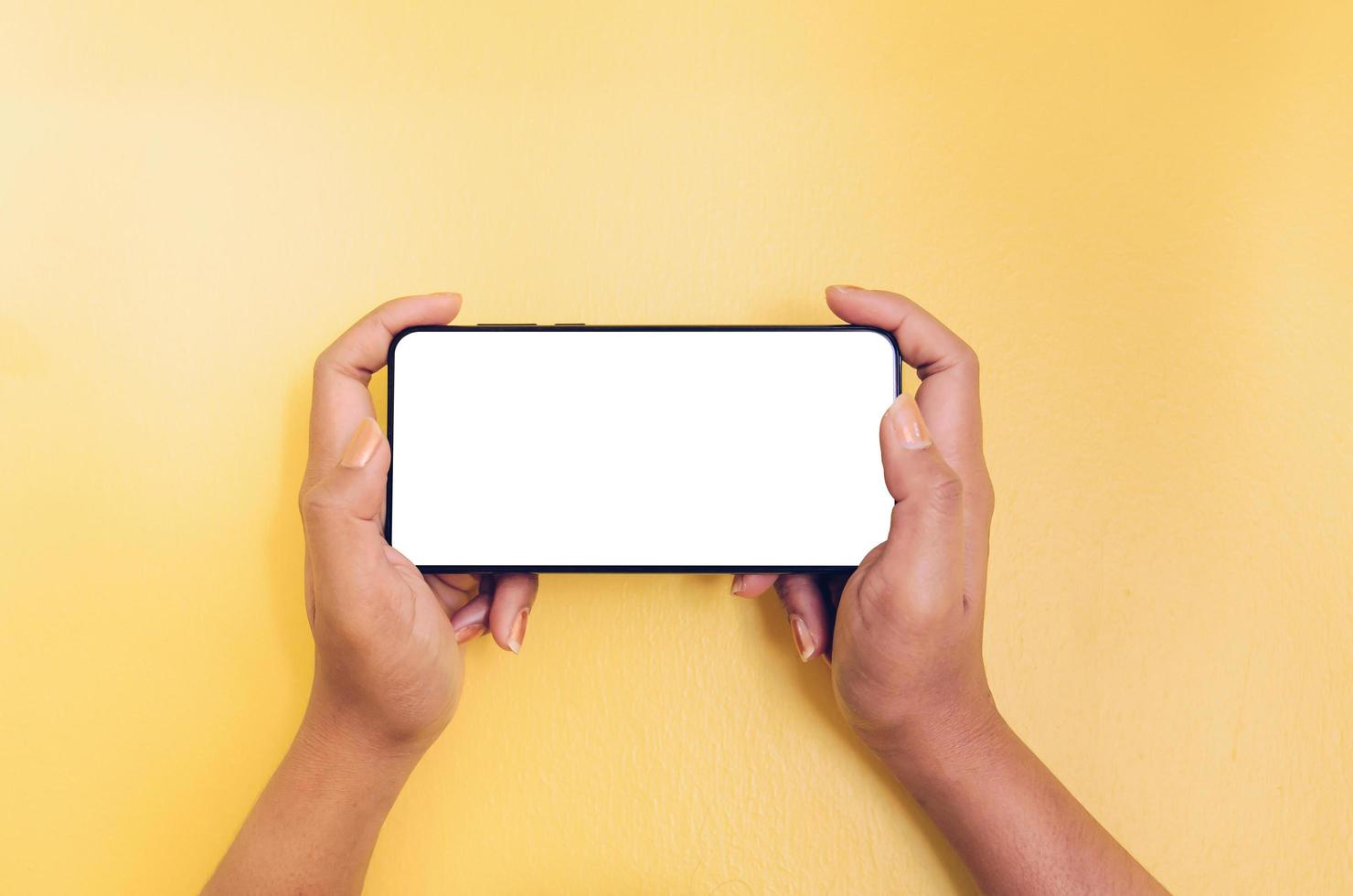 A hand holding smartphone with white screen background. photo