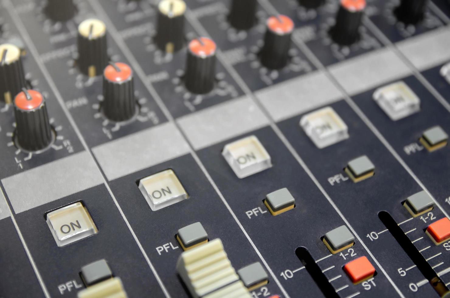 Consola mezcladora de audio y mezcla de sonido con botones y controles deslizantes. foto