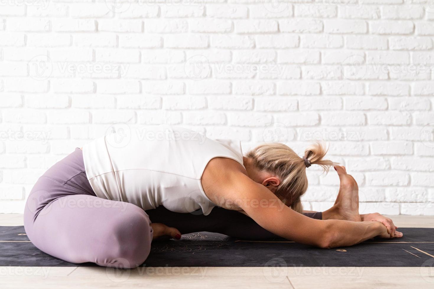 Young attractive woman practicing yoga, wearing sportswear photo