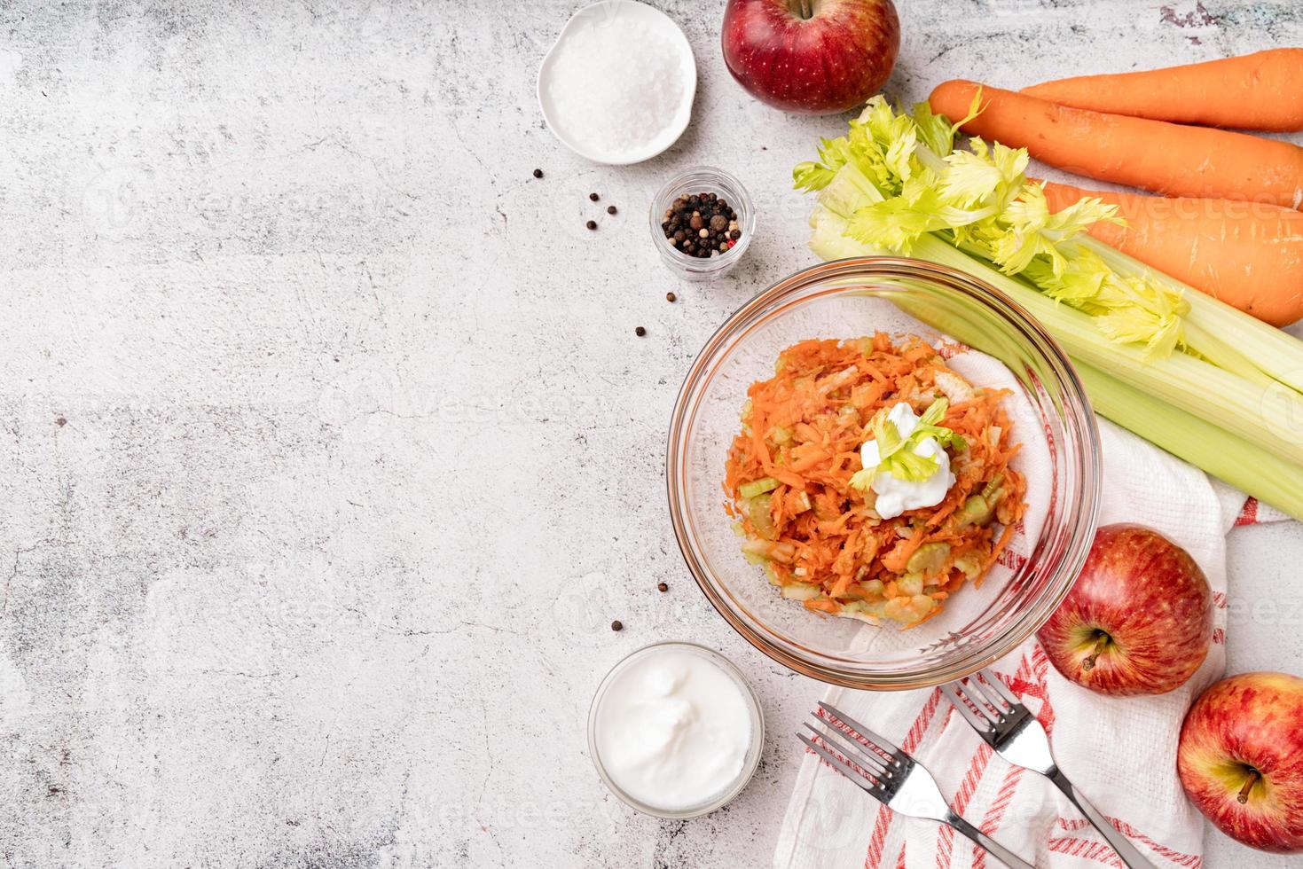 Tazón de ensalada de apio dietético con zanahorias y manzanas foto