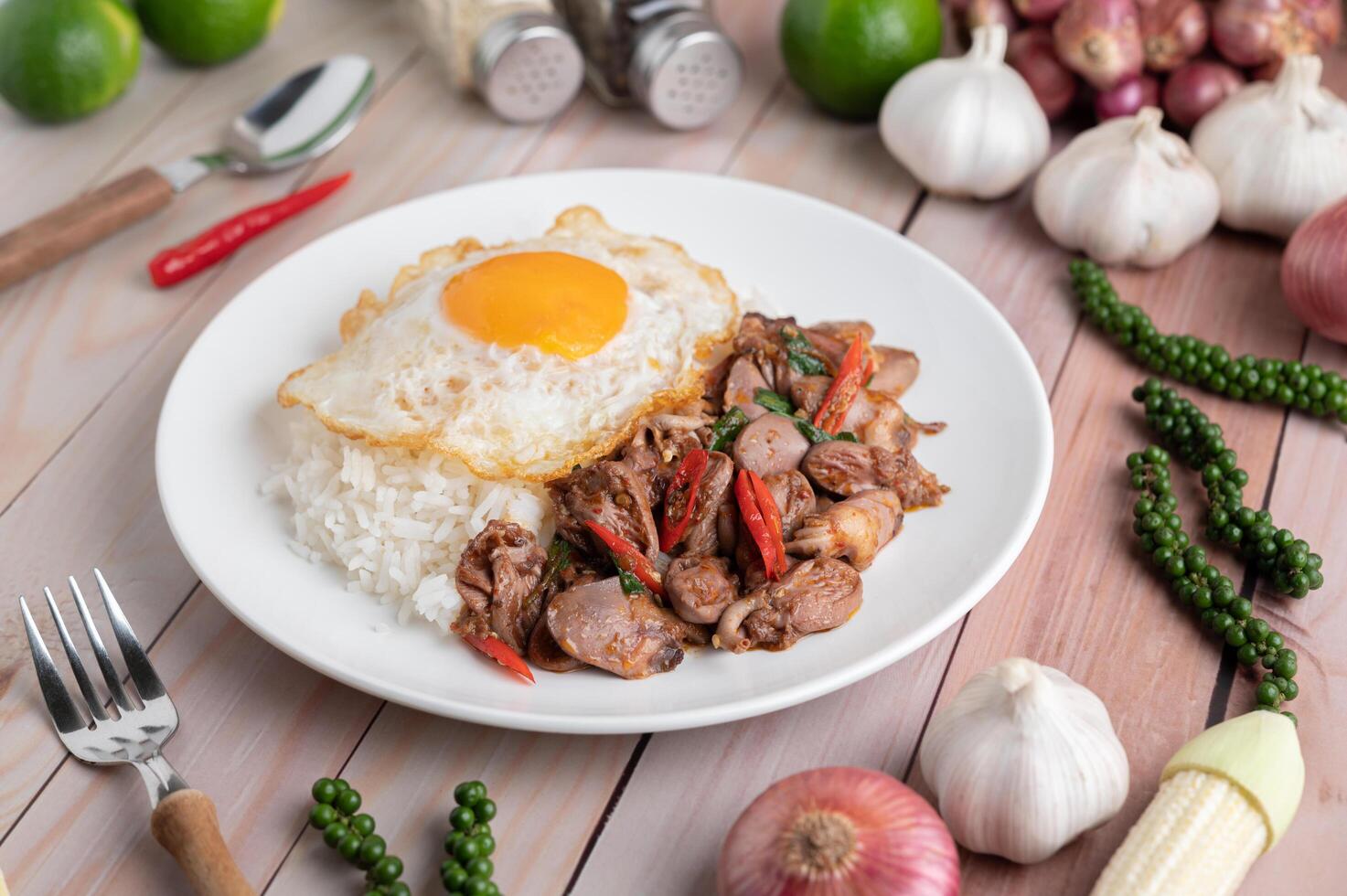 Arroz frito con albahaca sagrada con corazón de pollo y huevo frito foto