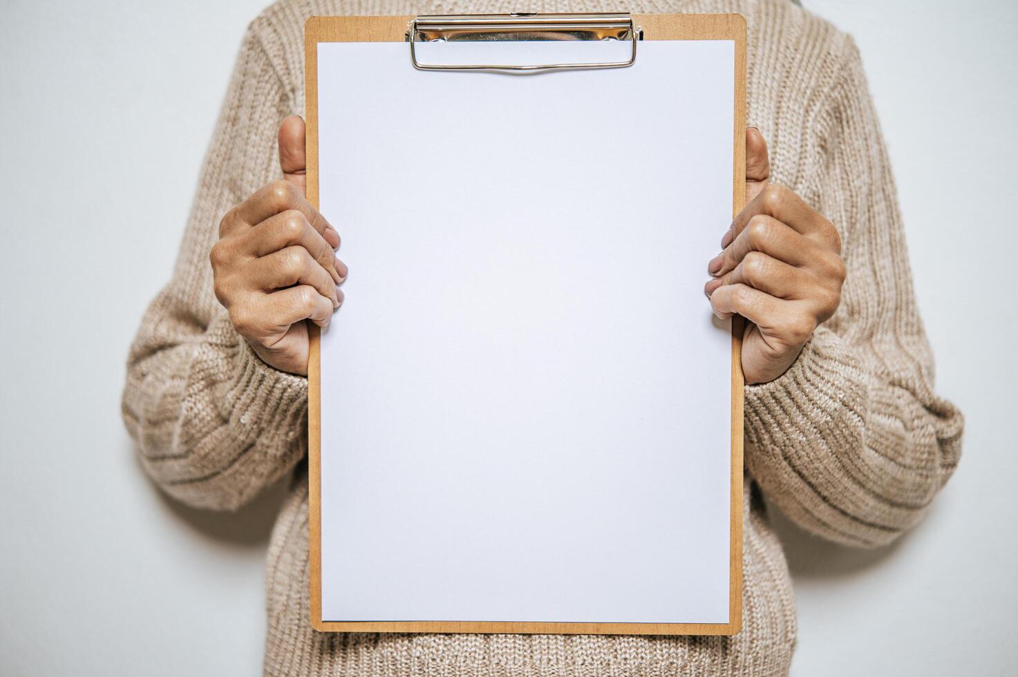 Person with long sleeves holds a clipboard on his chest photo