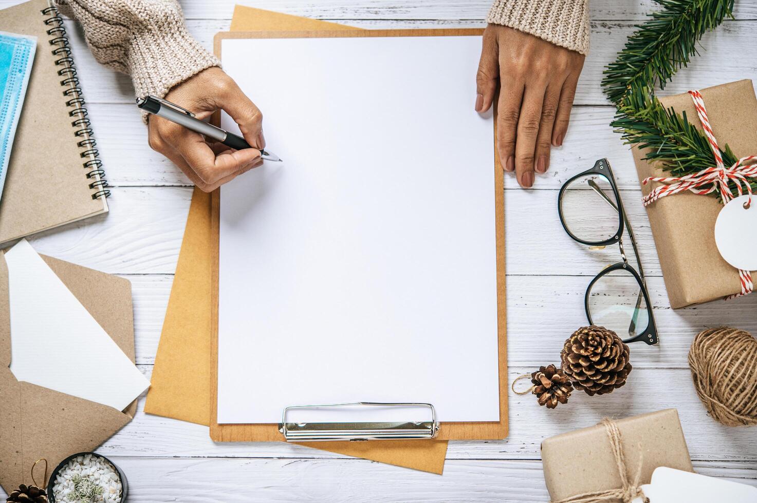 A hand holding a pen to write on a clipboard photo