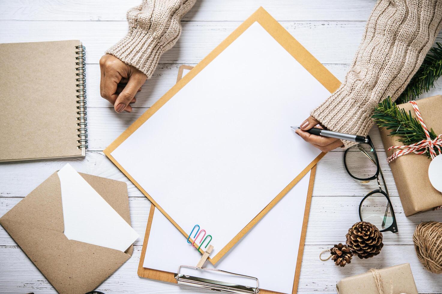 A hand holding a pen to write on a clipboard photo