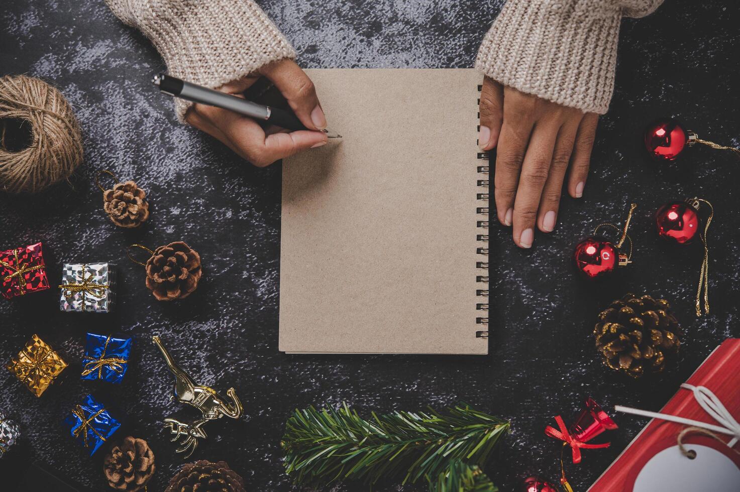 una mano sosteniendo un bolígrafo para escribir en un cuaderno con gafas foto