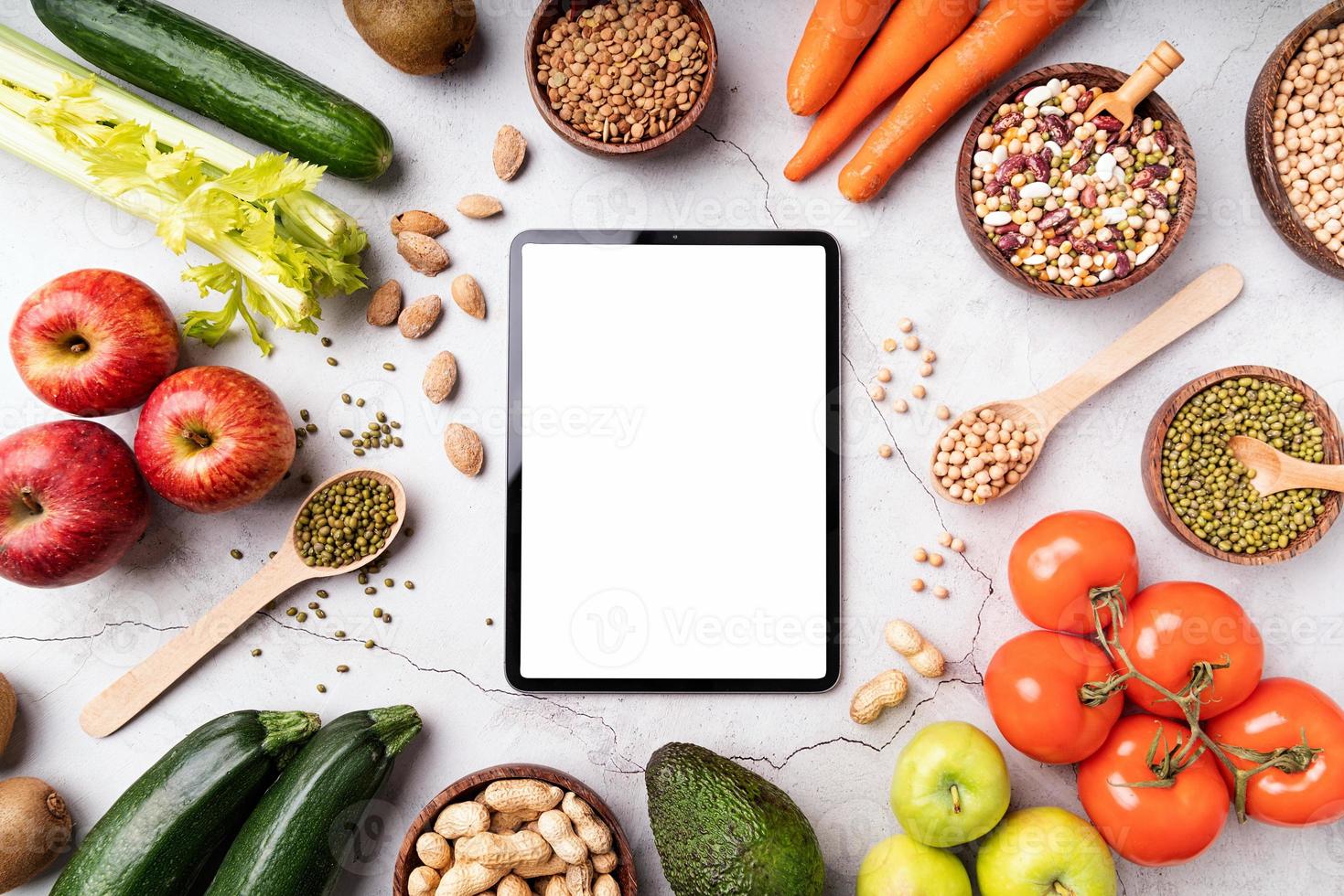 Vista superior de una tableta con pantalla blanca para simular alimentos saludables foto