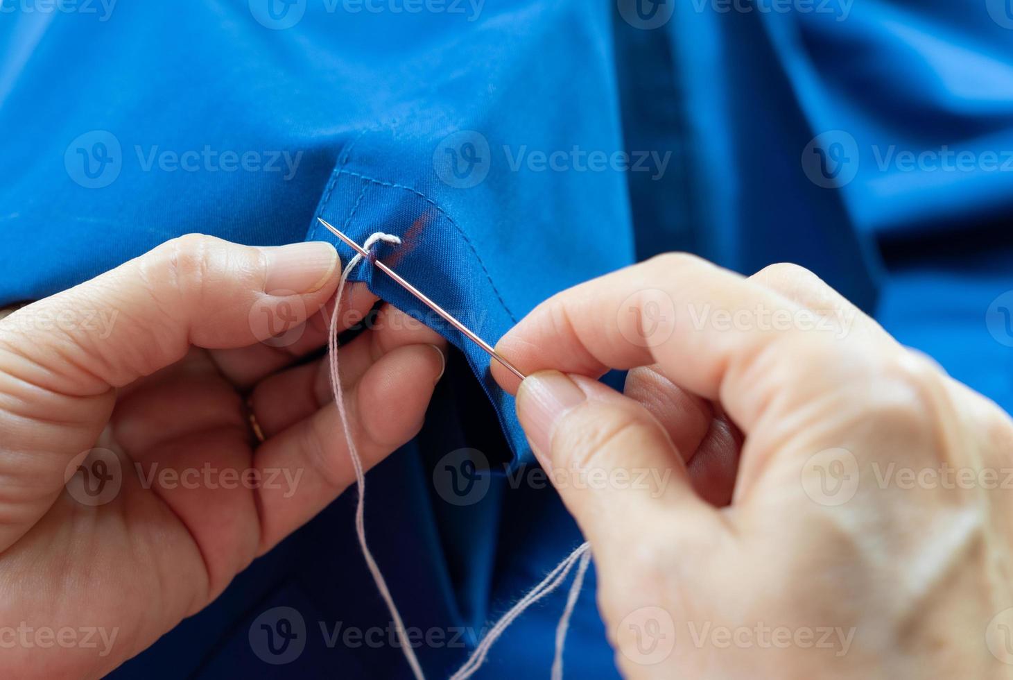 Woman using needle to sew photo