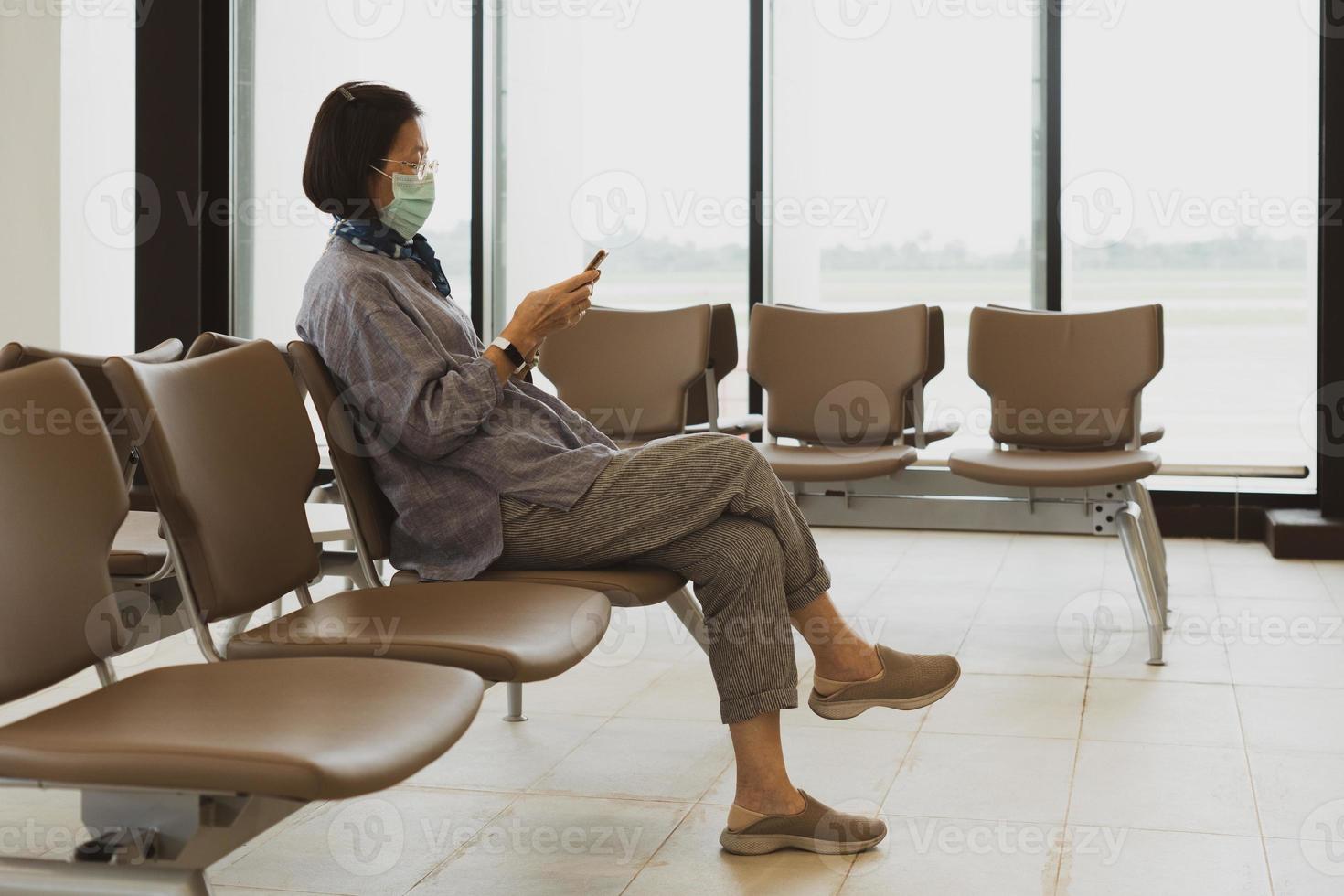 mujer enmascarada, sentado, en, aeropuerto foto